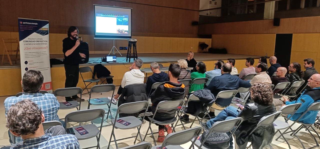 Auditorio con una persona dando una charla sobre comunidades energéticas a María de Huerva Energía